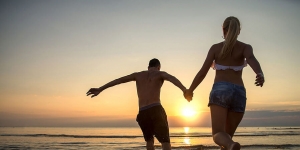 A couple run towards the setting sun on Sanibel Island