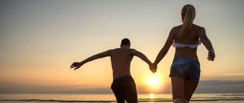 A couple run towards the setting sun on Sanibel Island