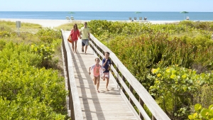 Family walking the boardwalk to enjoy the Florida beaches